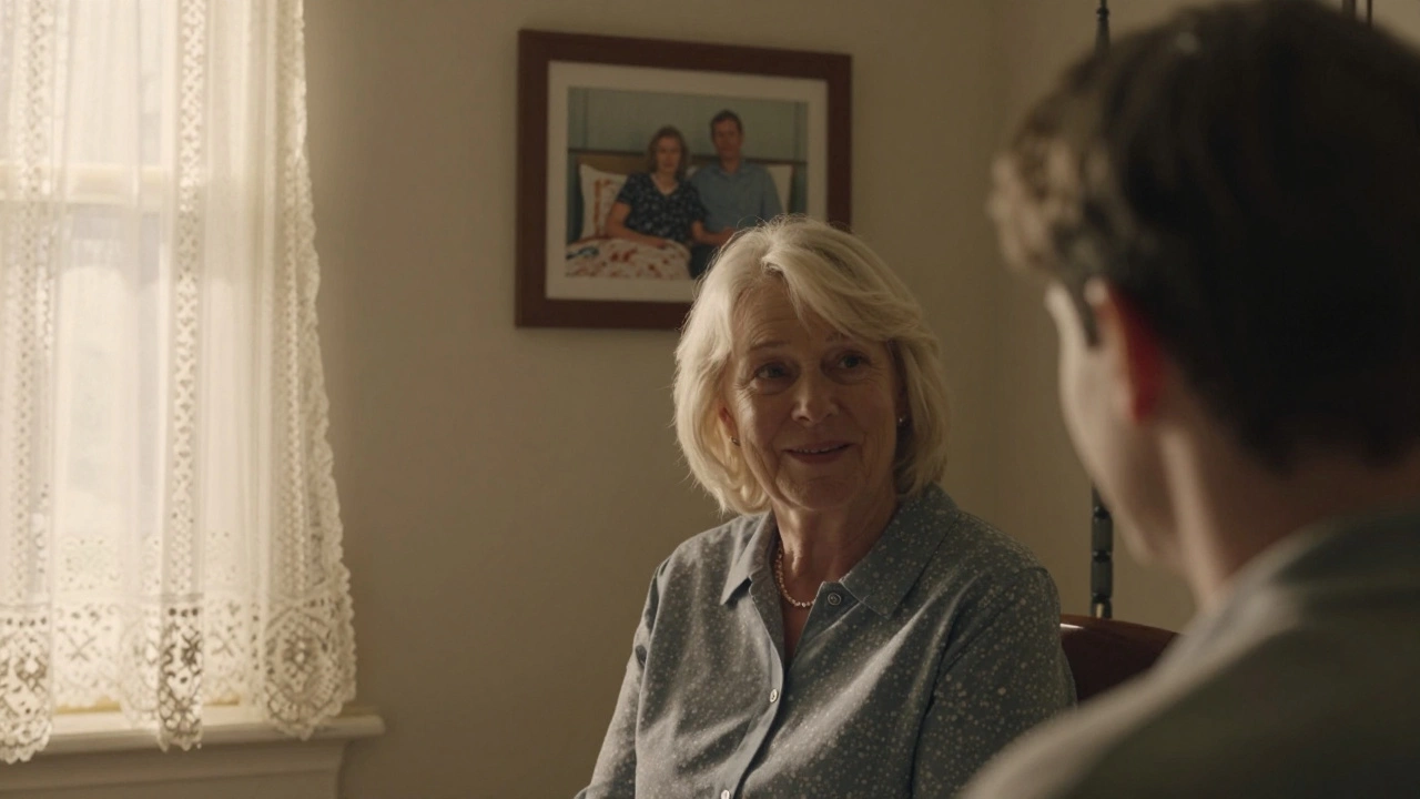 An older woman smiling beside a photo of her honeymoon bed, sunlight through lace curtains.